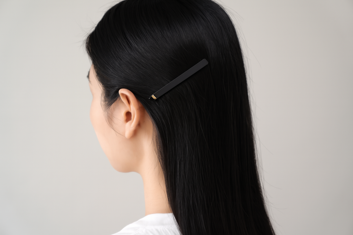 Generated lifestyle photo showing black hair clip in straight black hair